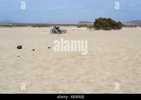 Zwei Mountainbikes in der Wüste Sand Dünen gegeneinander gelehnt, nicht fallen, weil der starke Wind Stockfoto