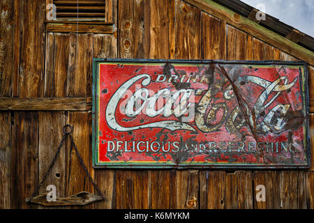 Trinken Coca Cola Schild - Vintage Coca Cola trinken, lecker und erfrischend Zeichen gegen eine hölzerne Struktur an einer Amerikanischen Südwesten Geisterstadt. Stockfoto