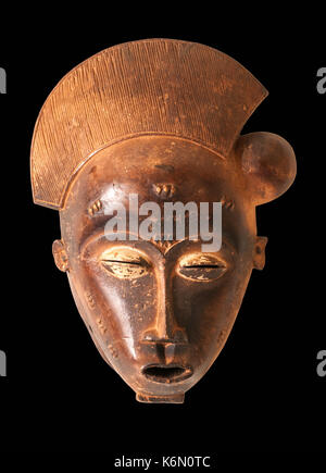 Eine Afrikanische zeremoniellen Maske in der Form einer weiblichen Figur in Holz isoliert auf schwarz geschnitzt. Stockfoto