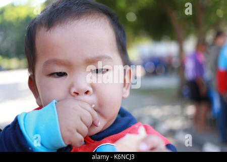 Asiatische junge Gesichter Süßigkeiten essen mit Freude, Konzept der Ernährung und Gesundheit der Kinder. Stockfoto