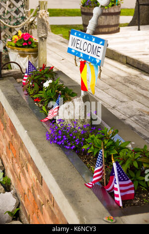Schild mit amerikanischen Fahnen in einer Blume Garten willkommen Stockfoto