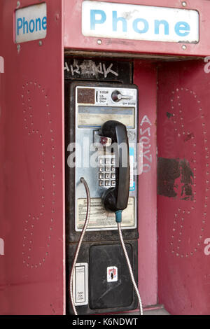 Verlassen" Antiken "münzautomaten öffentliches Telefon mit Münze release Steckplatz, Graffiti, alten Shopping Center, Kalifornien, USA. Stockfoto