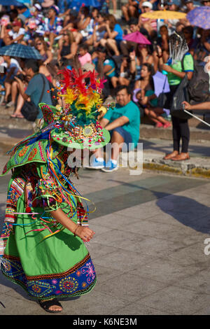 Tinkus-Tänzer gekleidet in prunkvollen Kostümen, die Durchführung während einer street Parade an der jährlichen Carnaval Andino Con la Fuerza del Sol in Arica, Chile. Stockfoto