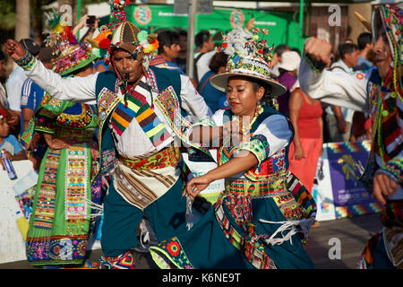 Tinkus-Tänzer gekleidet in prunkvollen Kostümen, die Durchführung während einer street Parade an der jährlichen Carnaval Andino Con la Fuerza del Sol in Arica, Chile. Stockfoto