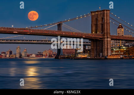 Super Mond über Manhattan und Brooklyn Bridges NYC - ein Blick auf die Brooklyn und Manhattan Bridge von Manhattan mit dem Super Mond und es ist b Stockfoto