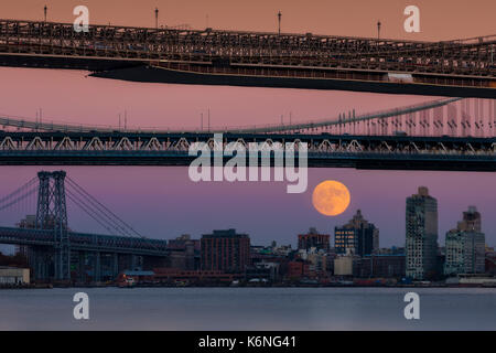 Super Mond über Manhattan New York City NYC Brücken - ein Blick auf die Williamsburg, Brooklyn und Manhattan Bridge von Manhattan mit dem Super Mond ri Stockfoto