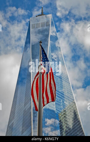 Amerikanische Flagge im World Trade Center WTC - die Vereinigten Staaten von Amerika Fahne schwingt im Wind mit dem Freedom Tower im Hintergrund. Blauer Himmel Stockfoto