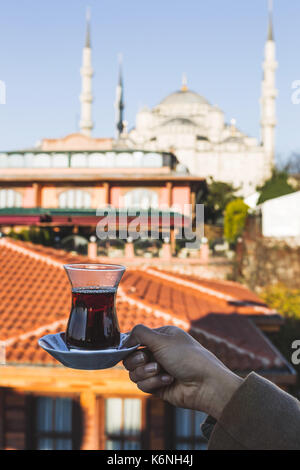 Frau mit Tasse traditionellen türkischen Kaffee auf der Terrasse mit Aussicht auf die Blaue Moschee. Schönen Morgen Sonnenlicht Stockfoto