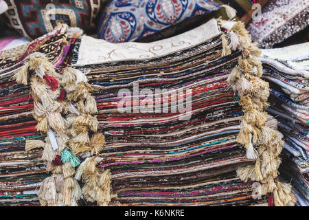 Haufen von schönen handgefertigten Teppichen auf dem Markt in Istanbul Grand Bazaar. Multicolor Hintergrund Stockfoto
