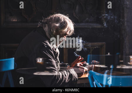 ISTANBUL, Türkei - Dezember 10, 2016: grauhaariger Mann trinkt Kaffee und raucht im Cafe Stockfoto