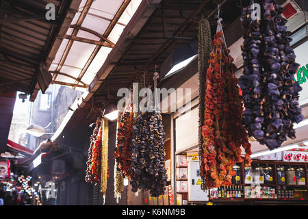 Getrocknete Früchte und Gemüse auf dem Markt verkauft, hängen an der Theke grosse Bündel Stockfoto