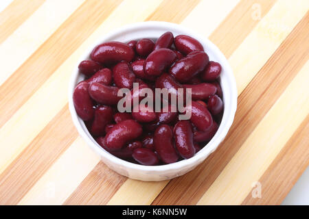 Heap in der Dose rote Bohnen in der Soße in weiße Schüssel. vegetarisches Essen. Phaseolus vulgaris. Stockfoto