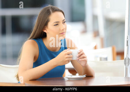 Single nachdenkliche Frau, die alleine mit einem Kaffeebecher sitzen in einer Bar Stockfoto