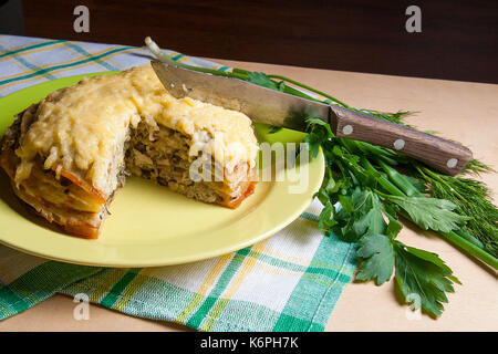 Pfannkuchen Sie-Torte mit Champignons und Hühnerfleisch, überbacken mit Käse auf grüne Platte. Ansicht des geschnittenen Pfannkuchen Kuchen auf Teller mit Kräutern grün: Dill, grüne Onio Stockfoto