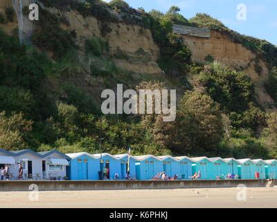 Eine Reihe von Blue Beach Huts zwischen Sandown, Shanklin, die unterhalb einer gefährlichen bröckelnden Felsen. Isle of Wight, Großbritannien. Stockfoto