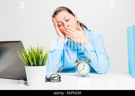 Müde Frau gähnt und will bei der Arbeit im Büro zu schlafen Stockfoto