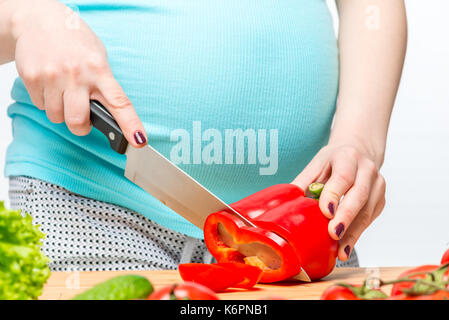 Nahaufnahme der Hand einer schwangeren Frau einen Salat Vorbereiten von Gemüse Stockfoto