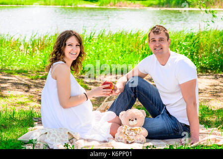 Lachen glücklich verheiratetes Paar auf Picknick, Frau schwanger Stockfoto
