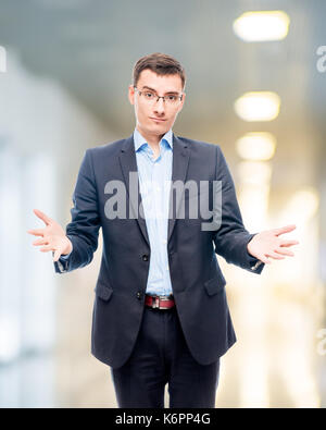 Junger Mann in Gläsern und Anzug im Büro posiert im Studio Stockfoto