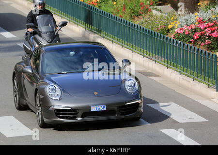 Monte Carlo, Monaco - 18. Mai 2016: Schöne Frau, die einen teuren Porsche 911 Carrera S auf der Avenue Princesse Grace in Monte Carlo, Monaco in der Stockfoto