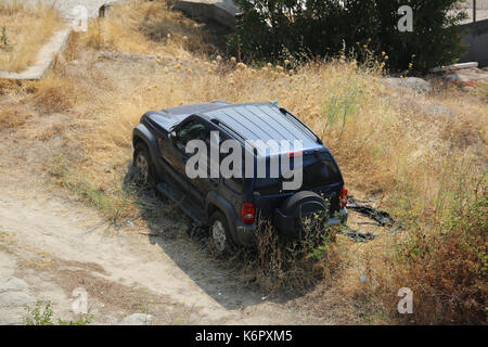 Kavala, Griechenland - 2. August 2016: Verlassene schöne schwarze Jeep Cherokee SUV in einem Feld in Kavala, Griechenland Stockfoto