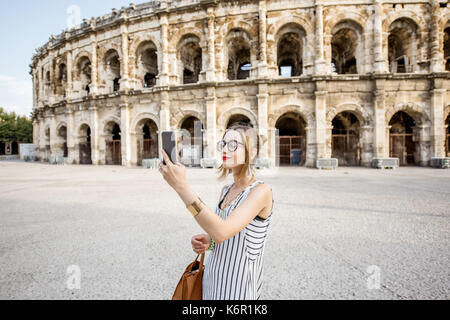 Lifestyle portrait einer jungen Unternehmerin zu Fuß in der Nähe der alten römischen Amphitheater in Nimes, Frankreich Stockfoto
