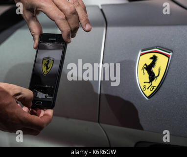 Ein Mann nimmt ein Bild des Ferrari Logo in Frankfurt am Main, Deutschland, 12. September 2017. Foto: Andreas Arnold/dpa Stockfoto