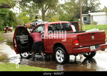 Orlando, USA. 12 Sep, 2017. Zwei Männer drücken Sie eine behinderte Pickup Truck mit persönlichen Besitztümern aus eine überflutete Straße in der Orlo Vista Nachbarschaft von Orlando, Florida, in den frühen Morgenstunden des 11. September überflutet wurde, 2017, als Hurrikan Irma durch den Bereich weitergegeben. Die Nationalgarde und Orange County Fire Rescue Personal gerettet 151 Bewohner von Häusern, die hatten so viel wie 4 Fuß Wasser in ihnen. 550 Häuser wurden beschädigt. Credit: Paul Hennessy/Alamy leben Nachrichten Stockfoto