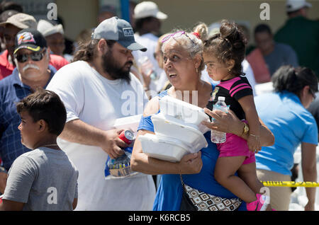 September 13, 2017 - Belle Glade, Florida, USA - lichtungen Bereich Bewohner abholen Mahlzeiten und Wasser bei einer Verteilung der Masse an NW 2. Straße und W Canal Street in Belle Glade, Florida am 13. September 2017. 2000 Mahlzeiten und Wasser wurden in Partnerschaft mit Christus Fellowship Church, PBC Food Bank, Home Depot, Zuckerrohr Züchter, Stadt von Belle Glade, Stadt der Pahokee und der Stadt South Bay verteilt. Der Plan für Donnerstag ist auf 3000 Mahlzeiten mit Eis und Wasser an der gleichen Stelle zu verteilen. (Bild: © Allen Eyestone/der Palm Beach Post über ZUMA Draht) Stockfoto