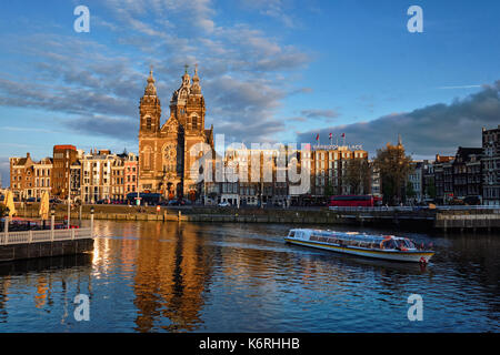 Touristenboot in Amsterdam den Kanal und die Kirche des Heiligen Nikolaus auf Stockfoto