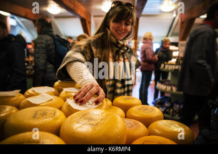Zaanse Schans, Niederlande - 26 April 2017: Junge Frau nimmt, holländischen Käse im Shop in Zaanse Schans, traditionelles Dorf Stockfoto