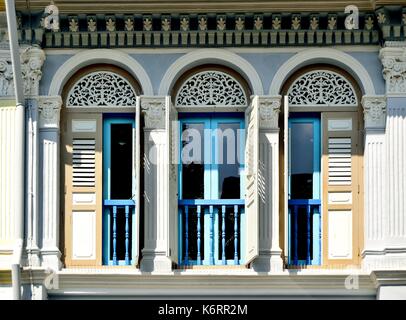 Traditionelle Singapur shop Haus außen mit Bogenfenster, hölzerne Lamellenfensterläden und verzierten Säulen im historischen Kampong Glam Bereich Stockfoto