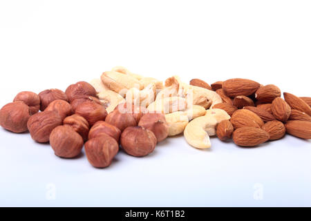 Gemischte Nüsse aus Haselnüssen, Mandeln, Cashews auf weißem Hintergrund. Selektive konzentrieren. Stockfoto