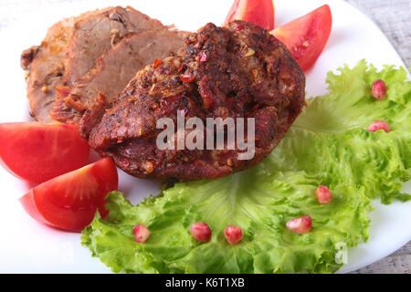 Steak gegrilltes Fleisch mit Tomaten, Kopfsalat und Bohnen Granatapfel auf weiße Platte. Stockfoto