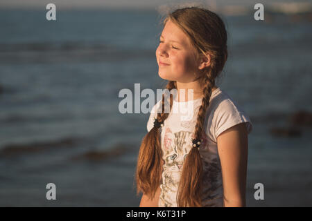 Junge Mädchen genießt die Wärme der Sonne Stockfoto