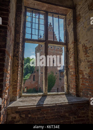 Spähend durch das Fenster einer Burgruine. Stockfoto