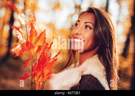 Porträt einer wunderschönen lächelnde junge Frau mit Blatt in der Natur im Herbst. Stockfoto