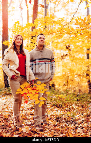 Schöne lächelndes Paar im sonnigen Wald im Herbst Farben. Stockfoto