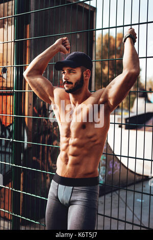 Junge, urbane, nachdenkliche Sportler Ausruhen nach dem Training in der Natur und weg schauen. Stockfoto