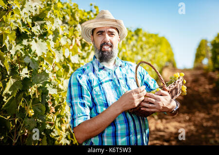 Schöner lächeln Wine Maker mit Strohhut auf einem Weingut. Stockfoto