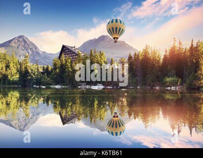 Den Sonnenaufgang über einem See im Nationalpark Hohe Tatra. Collage Berge und Ballon. Shtrbske Pleso, Slowakei, Europa Stockfoto