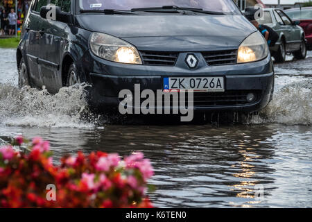 Sarbinowo, Polen - August 2017: Auto, das durch die überschwemmten Straße nach extrem starke Regenfälle Stockfoto