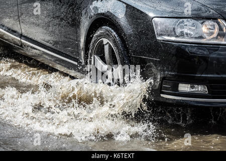 Sarbinowo, Polen - August 2017: Auto, das durch die überschwemmten Straße nach extrem starke Regenfälle Stockfoto