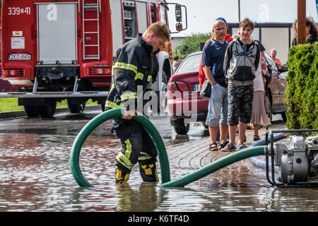 Sarbinowo, Polen - August 2017: Feuerwehr, Pumpen überschüssiges Wasser aus überschwemmte Straße nach schwerem Unwetter Stockfoto