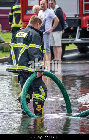 Sarbinowo, Polen - August 2017: Feuerwehr, Pumpen überschüssiges Wasser aus überschwemmte Straße nach schwerem Unwetter Stockfoto