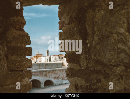 Abstrakte Wand mit Zaun mit Antibes, Frankreich im Hintergrund innerhalb des Rahmens Stockfoto