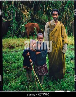 Burundi, Bujumbura Provinz, Ijenda, Tutsi cattleman mit zwei seiner Kinder, Tutsis sind traditionell Viehzüchter, Kuh ist für Sie ein fast heiliges Tier und stellt den Großteil ihres Reichtums mit dem Land, das sie bis 1976 gehörte, Kühe sind vor allem in der Zahlung der Mitgift verwendet, während der Zeremonien es Mode für Frauen war zu schwere Fußkettchen und Waffen tragen, um die eleganten Kuh bewegen (4 x 5 Umkehr film Reproduktion) Stockfoto