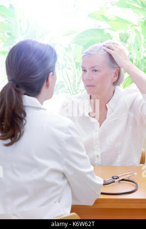 Ältere Frau zeigt ihre schütteres Haar oder Haarausfall zu Ihrer Ärztin oder Arzt, kopieren Raum Stockfoto