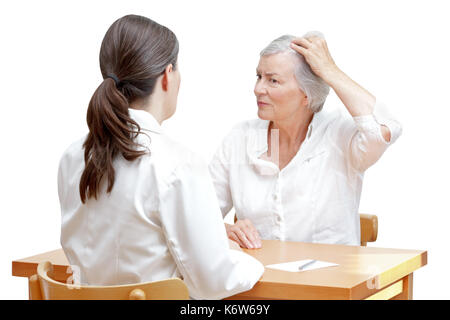 Ältere Frau zeigt ihre schütteres Haar oder Haarausfall zu Ihrer Ärztin, auf weißem Hintergrund Stockfoto