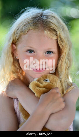 Kleines Mädchen mit blondem Haar und Kuscheltier, Schweden Stockfoto